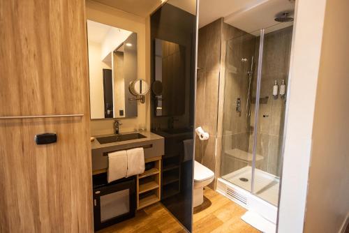 a bathroom with a shower and a sink and a toilet at Hotel Nodo - El hotel que respira in Santiago