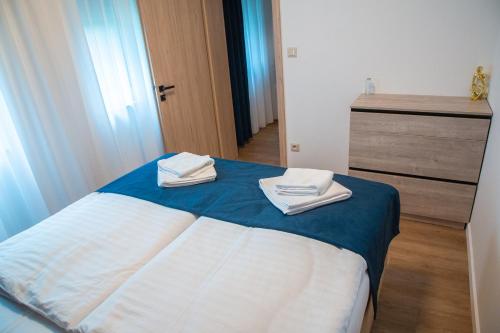 a bedroom with a bed with two towels on it at MILIA wine & event resort in Dunajský Klátov