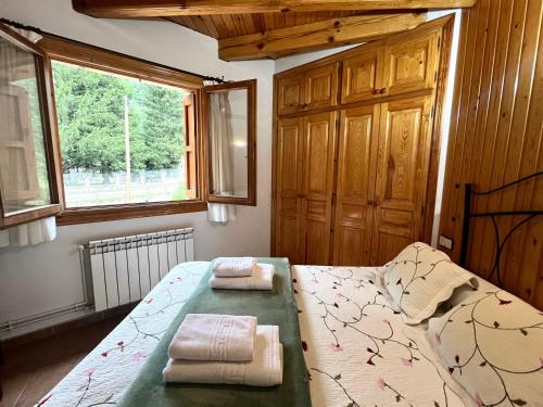 a bedroom with a bed with two towels on it at Apartament Àtic d'Espot - L'Amfitriona in Espot