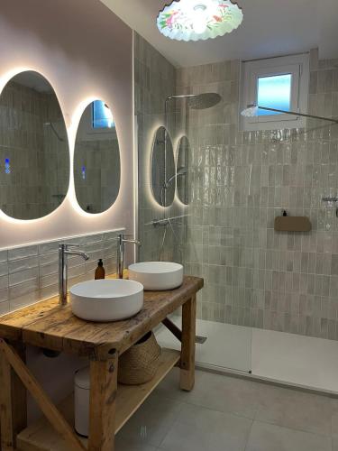 two sinks on a wooden table in a bathroom at La petite Maison Mima in Le Champ-sur-Layon