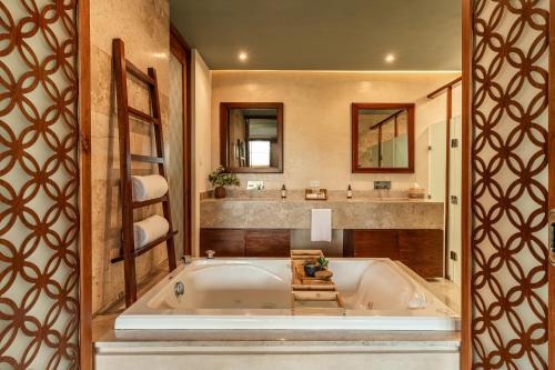 a bathroom with a large tub and a sink at Villas Caracol in Holbox Island