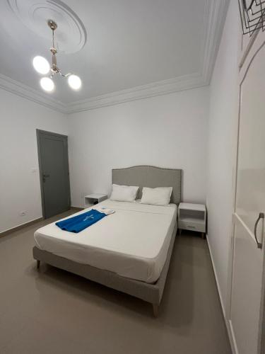 a bedroom with a bed with a blue blanket on it at Dream Garden Djerba in Djerba