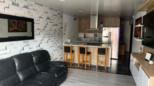 a living room with a couch and a kitchen at Apartamento Simón Bolívar in Itagüí