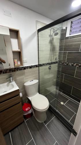 a bathroom with a toilet and a glass shower at Apartamento Simón Bolívar in Itagüí