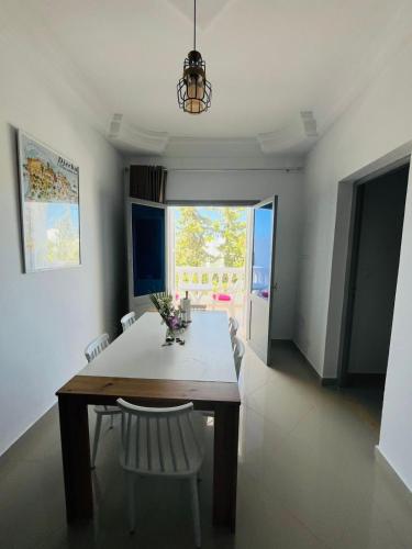 a dining room with a table and chairs and a window at Dream Garden Djerba in Djerba