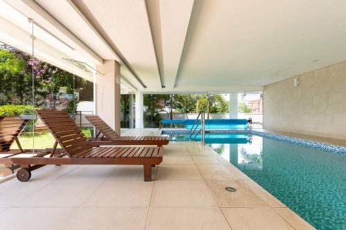 a pool with two lounge chairs and a swimming pool at Studio Executivo c/ Garagem – Granja Viana | Cotia in Cotia