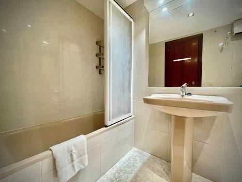 Un baño con lavabo, ducha y espejo. en Dream penthouse with BBQ&Pool, en Cambrils