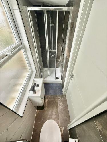a small bathroom with a toilet and a shower at The Goldsmith Residence - 43 - Prime Locaton Rooms in London