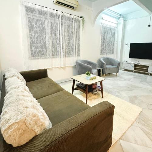 a living room with a couch and a tv at RapaatVip Homestay in Ipoh