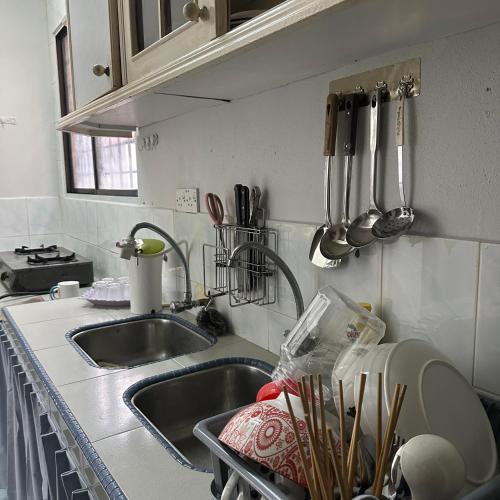 a kitchen sink with utensils on the wall at RapaatVip Homestay in Ipoh