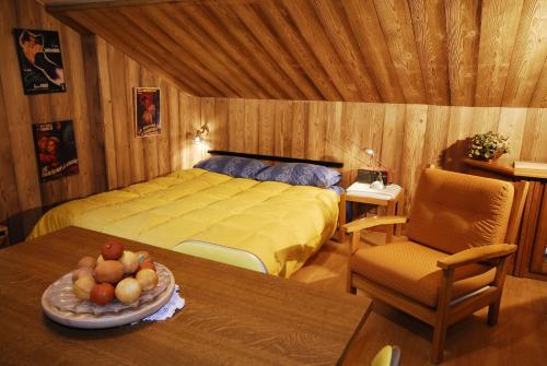 ブレウイル・チェルヴィナイアにあるResidence Petit Tibetのベッドルーム1室(ベッド1台、テーブル、フルーツボウル付)