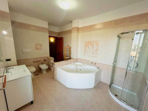 a bathroom with a tub and a shower and a toilet at Dimora Il Roseto in Trani