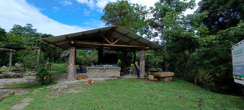 a pavilion with a dog laying in the grass at La Granja De Bam Bam in Sasaima