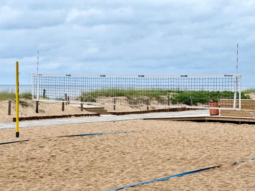 a volleyball net in the sand on a beach at Villa Gāles Hotel in Saulkrasti