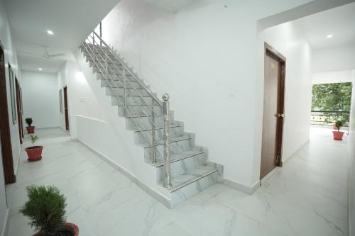 a staircase in a room with white walls and white tile floors at Hotel Park View in Khajurāho