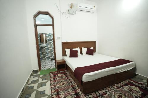 a bedroom with a large bed and a mirror at Hotel Park View in Khajurāho