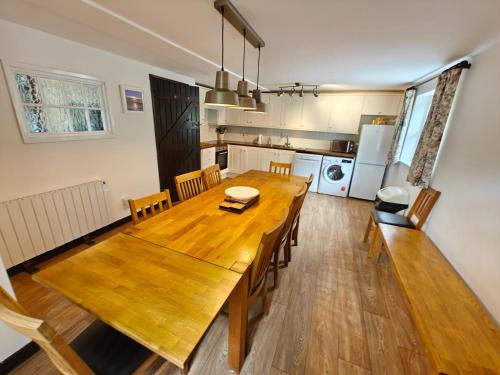 a kitchen and dining room with a wooden table and chairs at Linhay -Farm Cottage in Sidmouth