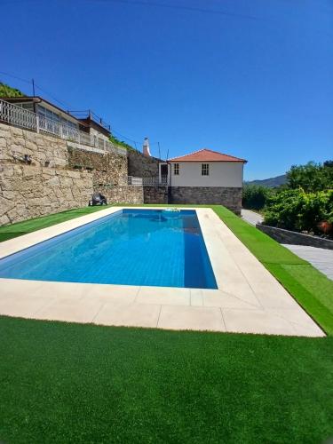 a swimming pool in a yard with green grass at Casa da Quinta do Porto in Lamego