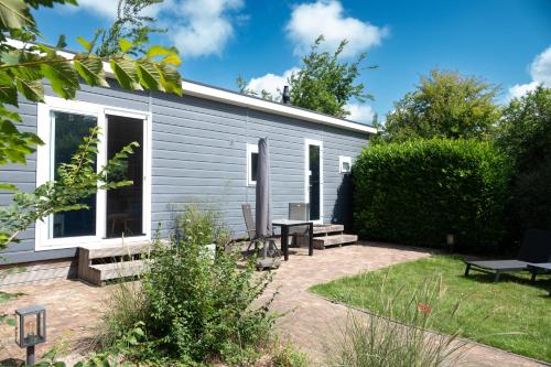 a backyard with a shed with a picnic table and benches at De Zilte Zeehoeve in Ellemeet