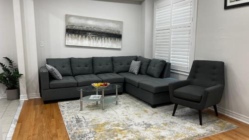 a living room with a couch and a chair at Four Bedroom Spacious House with Parking in Milton, Ontario in Milton