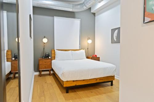 a bedroom with a white bed and a mirror at Sosuite at The Vine - Old City in Philadelphia