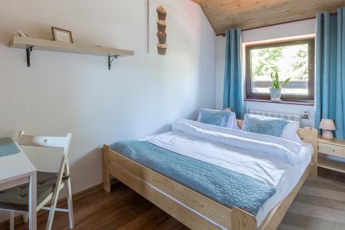 a bedroom with a bed and a desk and a window at Szymonówka W Szklarskiej Porębie in Szklarska Poręba