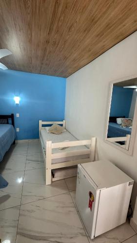 a small room with two beds and a mirror at Alfa Mar Pousada in Abraão