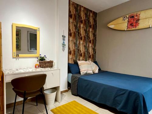Un dormitorio con una cama y una tabla de surf en la pared. en Amanecer Isleño Habitaciones, en Arrecife
