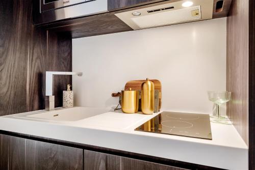 un bancone della cucina con lavandino e computer portatile di Hounslow Central Studio Aparments a Hounslow