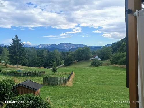 a field of green grass with mountains in the background at Ferienhaus Familie Zimmermann in Keutschach am See
