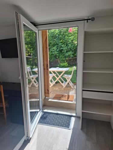 a sliding glass door with a view of a patio at Charmant studio RDC avec terrasse, parking & cuisine équipée in La Côte-Saint-André