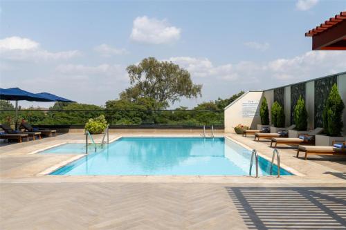 a swimming pool with benches and a building at Radisson Blu Hotel, Nairobi Upper Hill in Nairobi