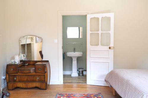 a bedroom with a bed and a sink and a mirror at Contes à Rebours - Chambres d'hôtes in Morlaix