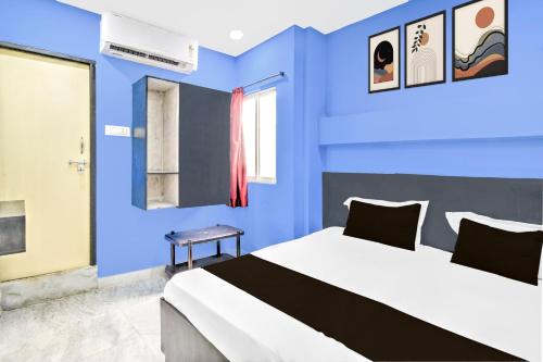 a blue room with a bed and a window at Hotel O HOLIDAY STAR IN in Hyderabad