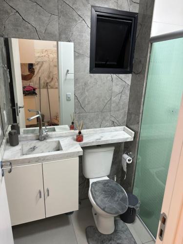a bathroom with a sink and a toilet and a mirror at Apartamento 1 dorm,com ar,frente faculdade in São Paulo