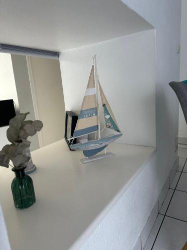 a toy boat sitting on a shelf in a room at Sweet'Nest Dinard - Le Charme Breton in Dinard