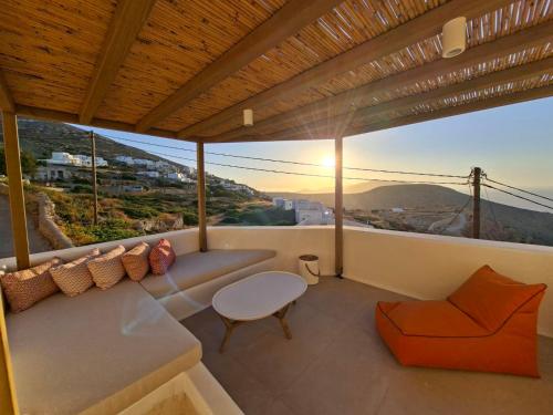 a balcony with a couch and a table and a view at ANDELIAS Signature Suites in Chora Folegandros