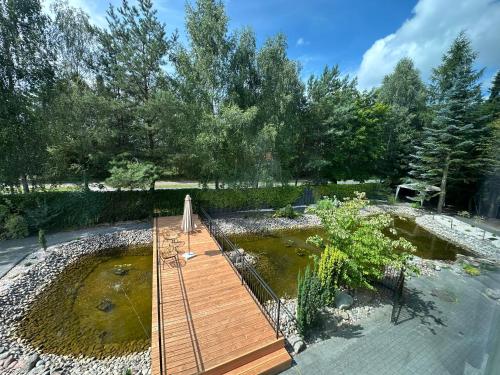 a wooden boardwalk in a pond in a yard at Apartamenty Terminal Charzykowy in Charzykowy