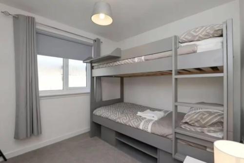 a bedroom with two bunk beds and a window at 3-BR Family Home Near St Andrews in Fife