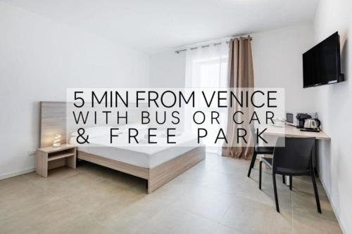 a living room with a desk and a table with a computer at Appia Rooms Free Parking e Fast Access to Venice by Bus in Venice