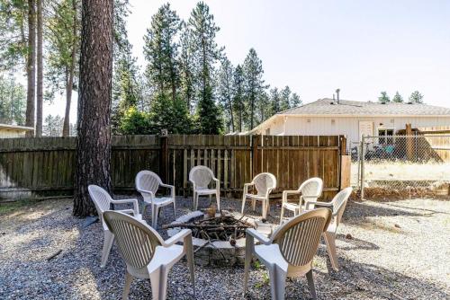 a group of chairs sitting around a fire in a yard at Cozy 3-Bedroom Retreat with Fenced Yard, Games & BBQ- Pet Friendly in Coeur d'Alene