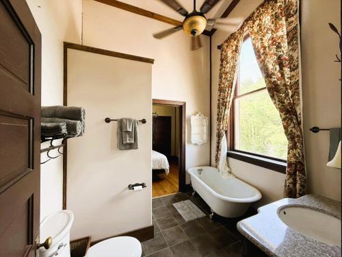 a bathroom with a toilet and a tub and a sink at Above the Shot Harrisons Gem in Harrison