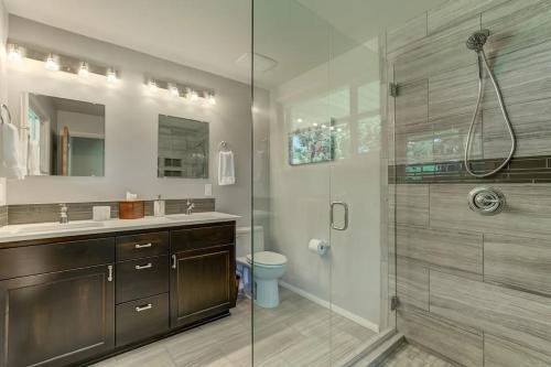 a bathroom with a glass shower and a toilet at Welk Manor Private Waterfront Retreat on the Spokane River in Post Falls
