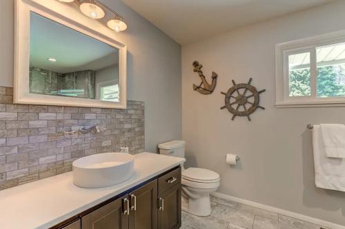 a bathroom with a sink and a toilet and a mirror at Welk Manor Private Waterfront Retreat on the Spokane River in Post Falls