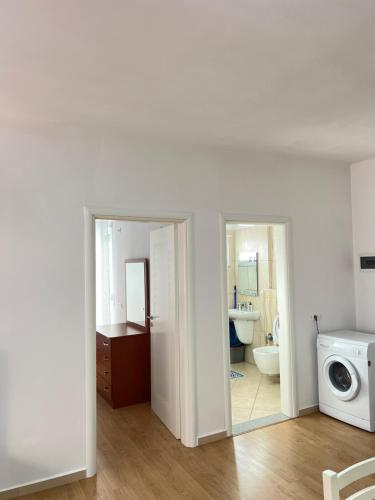 a white room with a bathroom with a washing machine at Cameria in Durrës