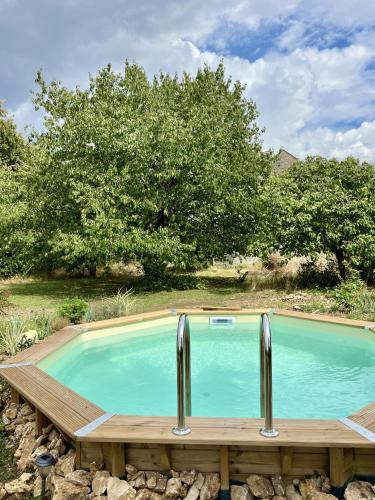 une grande piscine avec une terrasse en bois à côté de celle-ci dans l'établissement La Vieille Ferme de Tassigny, à Meursault
