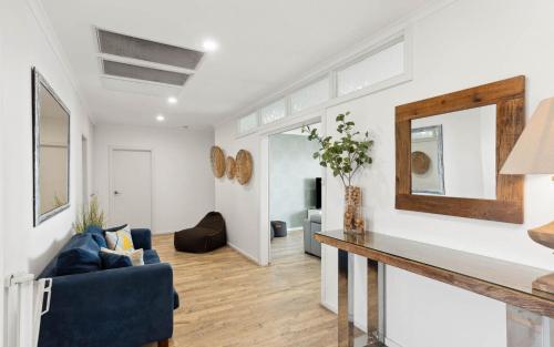 a living room with a blue couch and a mirror at 35 Degrees South in Port Noarlunga