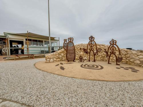 a statue of owls sitting on a circle in front of a building at Leeside in Goolwa South