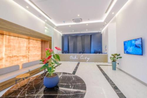 a waiting room with a couch and a table with a plant at Luxury Living Orbi City Batumi in Batumi
