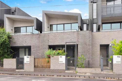 a large brick building with doors and gates at MHYL Cosy Townhouse in Richmond 1 parking in Melbourne